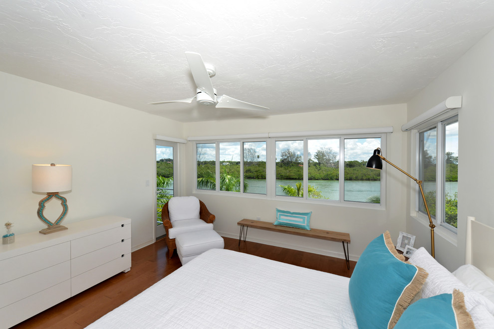 Foto de habitación de invitados tropical de tamaño medio sin chimenea con paredes beige, suelo de madera oscura y suelo marrón