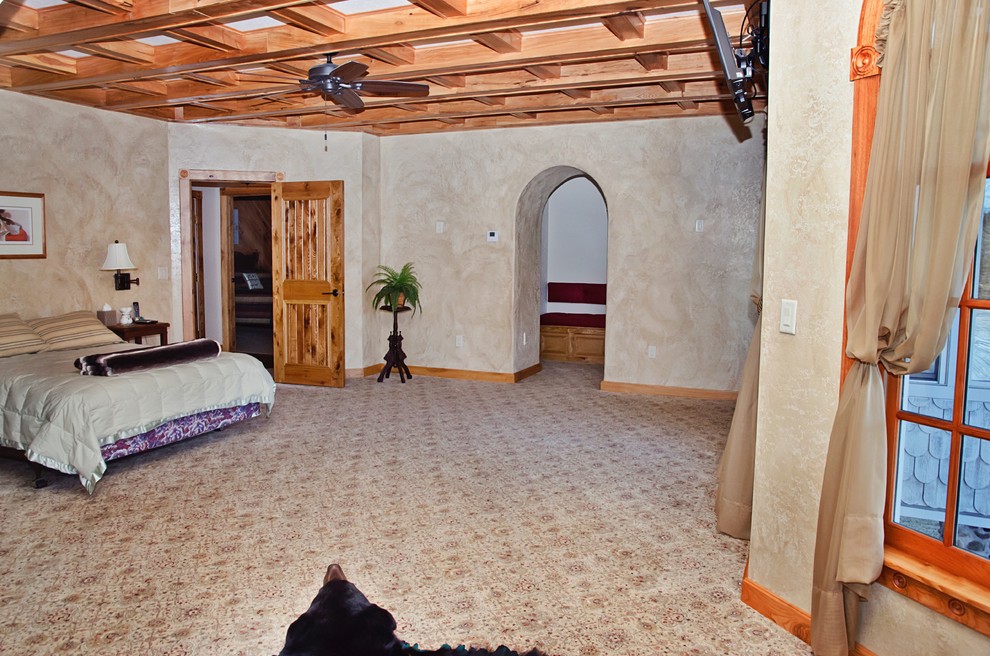Example of a large mountain style master carpeted and beige floor bedroom design in Other with beige walls and no fireplace