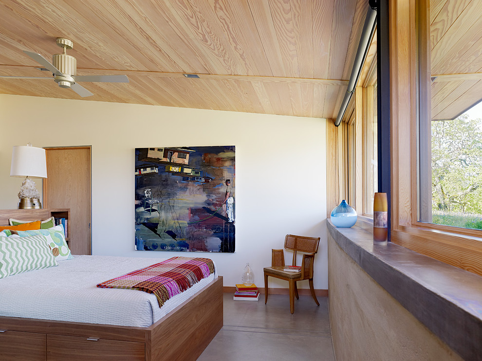 Exemple d'une chambre tendance avec sol en béton ciré.