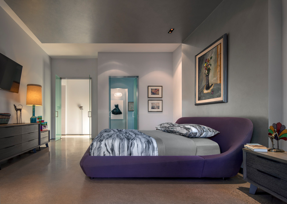 Immagine di una camera da letto design con pareti grigie, pavimento in cemento e pavimento grigio