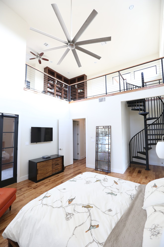 Mittelgroßes Modernes Hauptschlafzimmer ohne Kamin mit weißer Wandfarbe, braunem Holzboden und braunem Boden in Dallas