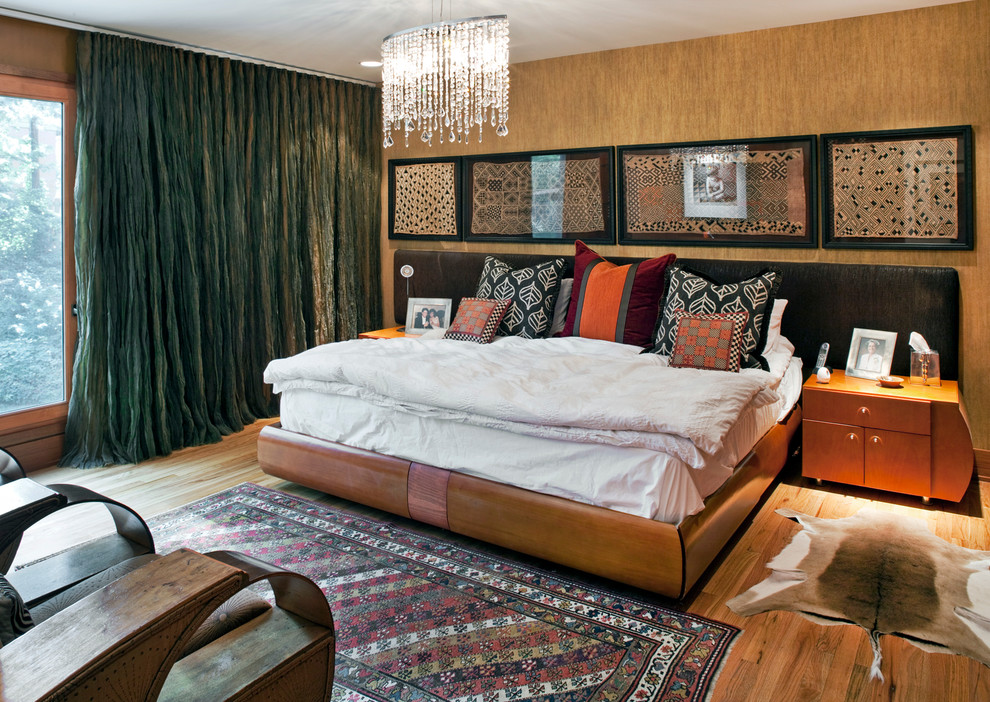 Foto di una camera matrimoniale design con pareti beige e pavimento in legno massello medio