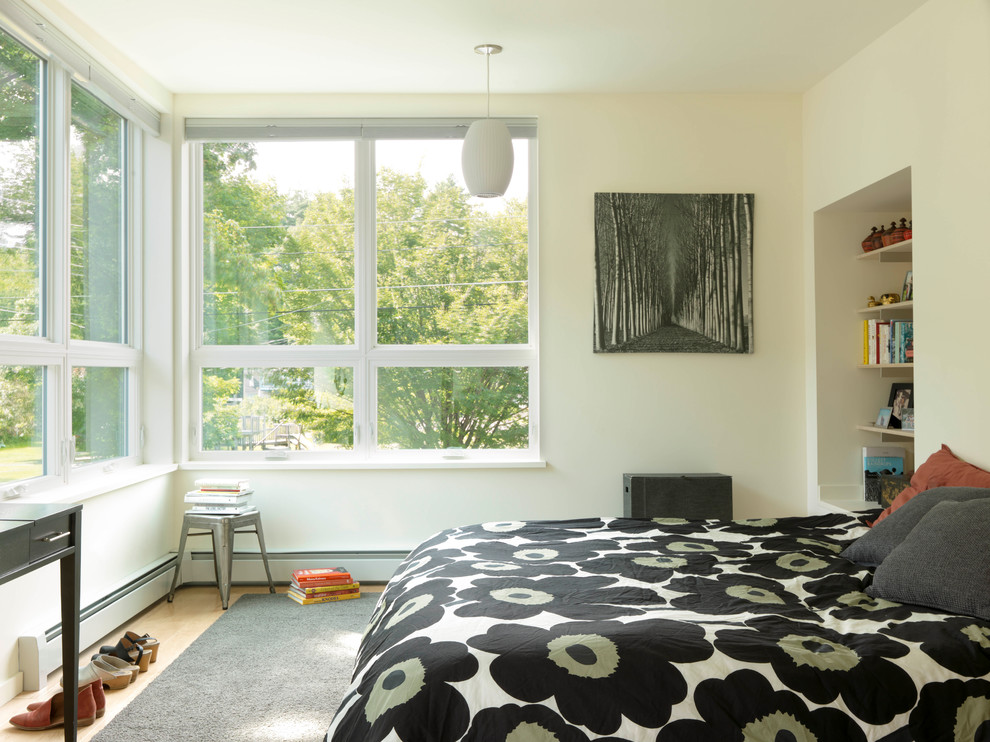 Photo of a contemporary cream and black bedroom in Burlington with white walls and light hardwood flooring.