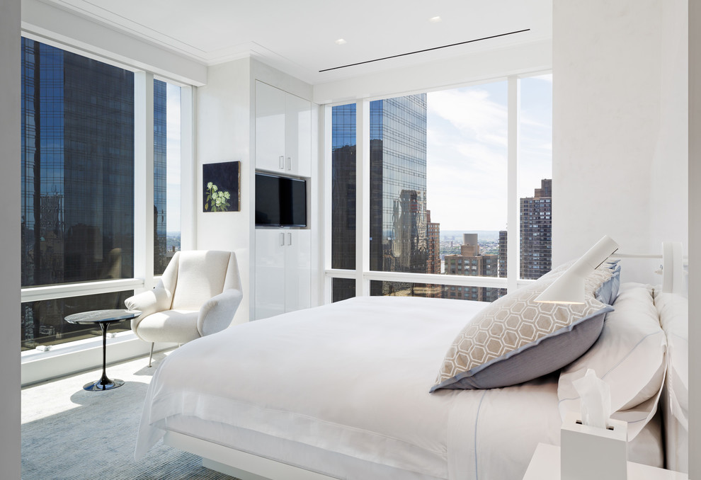 Immagine di una camera da letto design con pareti bianche e moquette