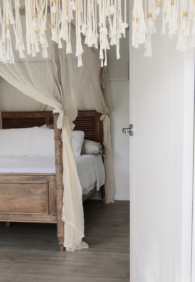 Diseño de dormitorio principal costero grande con paredes blancas y suelo vinílico