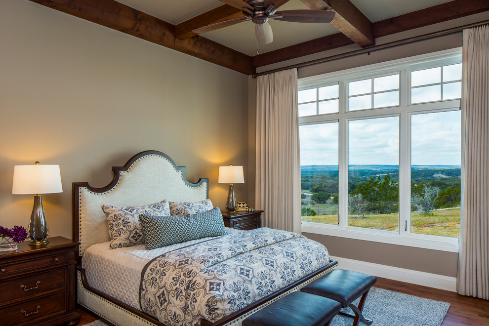 Landhaus Hauptschlafzimmer mit beiger Wandfarbe und braunem Holzboden in Austin
