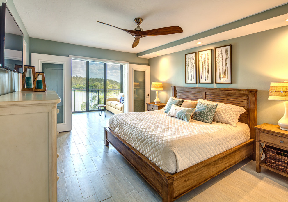 Diseño de dormitorio principal marinero con paredes azules, suelo de madera clara y suelo gris