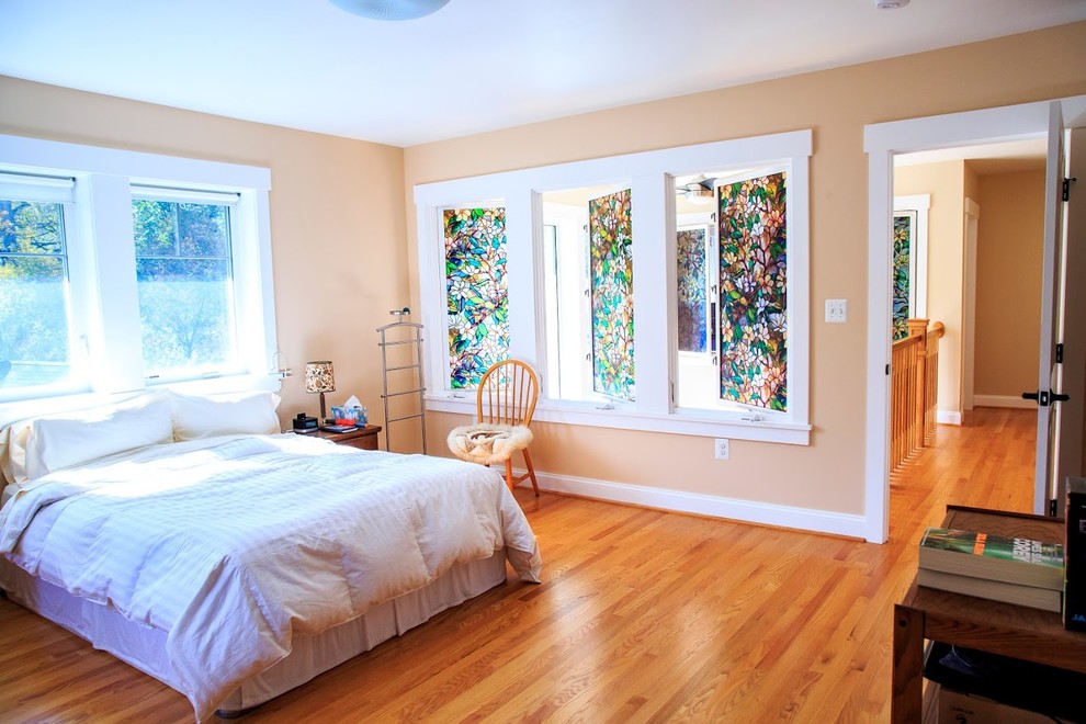 Cette image montre une chambre d'amis rustique de taille moyenne avec un mur beige, un sol en bois brun et aucune cheminée.