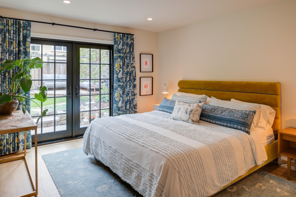 Modelo de dormitorio principal clásico renovado de tamaño medio con paredes beige, suelo de madera clara y suelo marrón