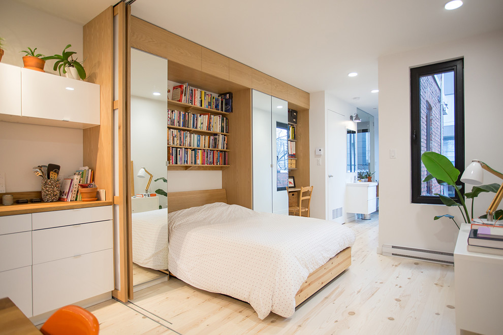 Foto på ett funkis sovrum, med vita väggar, ljust trägolv och beiget golv