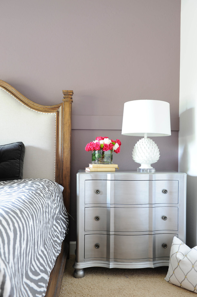 Large bohemian guest bedroom in Phoenix with carpet, purple walls and beige floors.