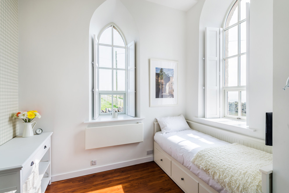 Foto di una camera degli ospiti country con pareti bianche e pavimento in legno massello medio