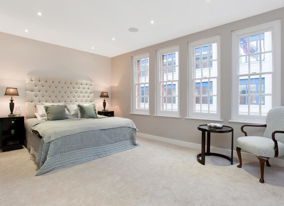 Inspiration for a large contemporary master bedroom in London with beige walls and carpet.