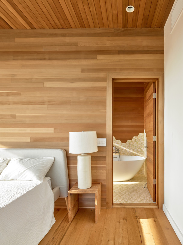 Ejemplo de dormitorio principal marinero con suelo de madera en tonos medios y suelo marrón