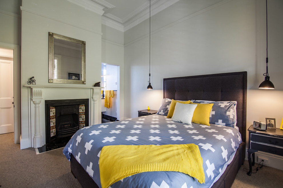 На фото: спальня в стиле неоклассика (современная классика) с серыми стенами, ковровым покрытием, стандартным камином и коричневым полом с