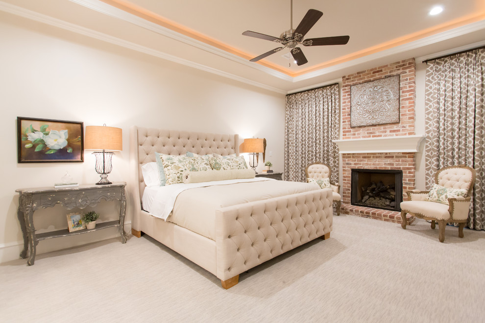 На фото: хозяйская спальня в классическом стиле с бежевыми стенами, ковровым покрытием, стандартным камином и фасадом камина из кирпича