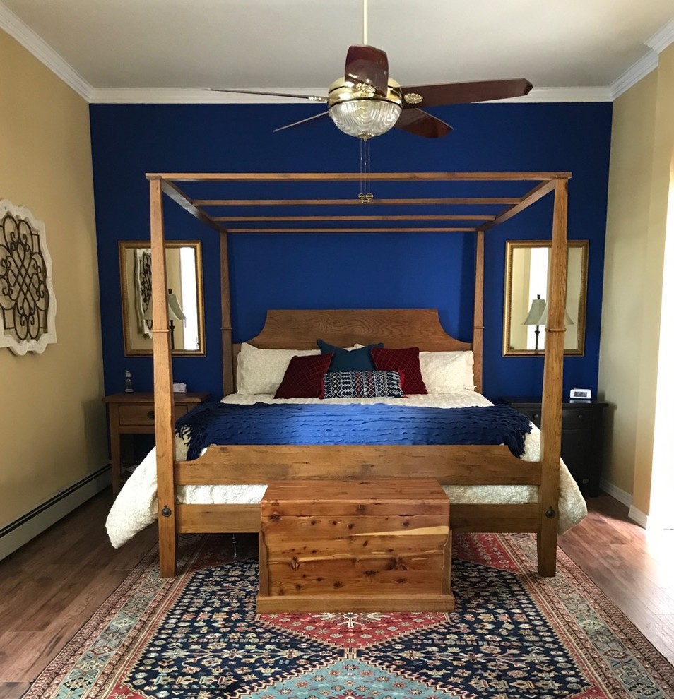 Foto de habitación de invitados mediterránea de tamaño medio sin chimenea con paredes azules, suelo de madera en tonos medios y suelo marrón