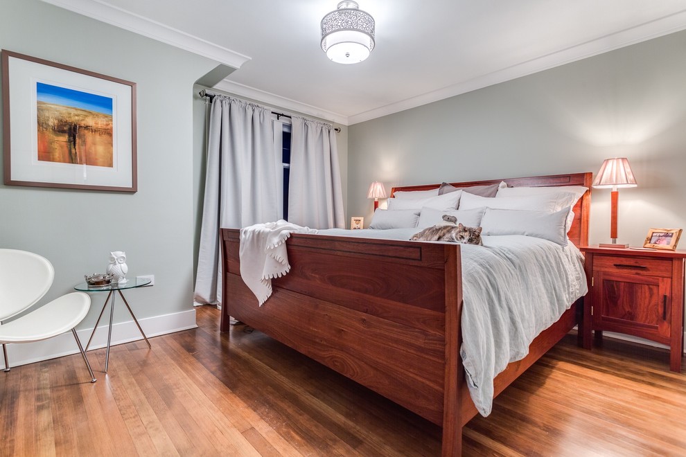 Diseño de dormitorio principal tradicional de tamaño medio con paredes azules y suelo de madera en tonos medios
