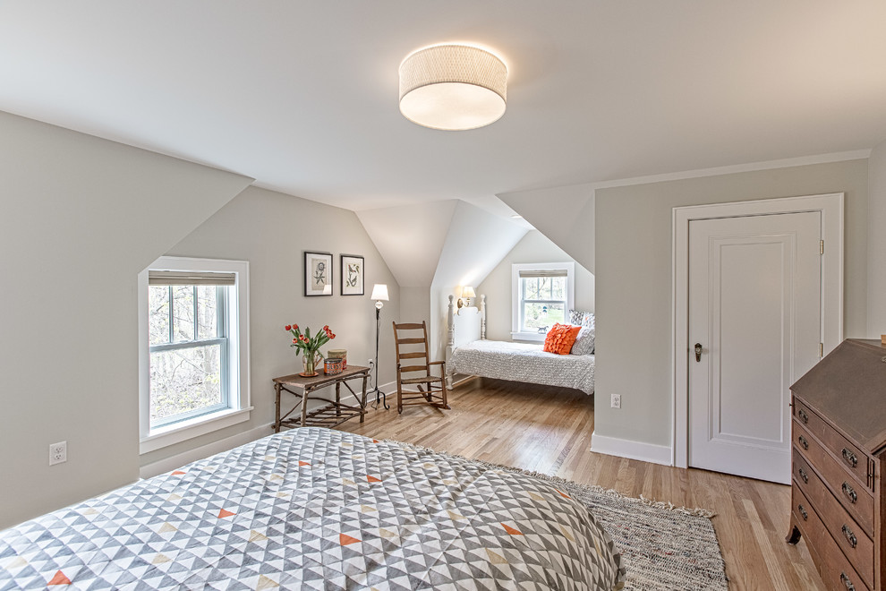 Ejemplo de habitación de invitados de estilo americano de tamaño medio sin chimenea con paredes grises y suelo de madera clara