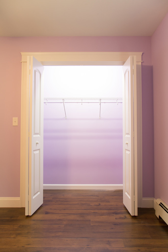 Cette image montre une chambre d'amis minimaliste avec un mur violet et parquet foncé.