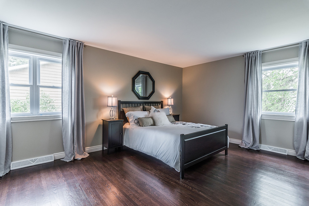 This is an example of a medium sized contemporary master bedroom in Montreal with dark hardwood flooring and grey walls.