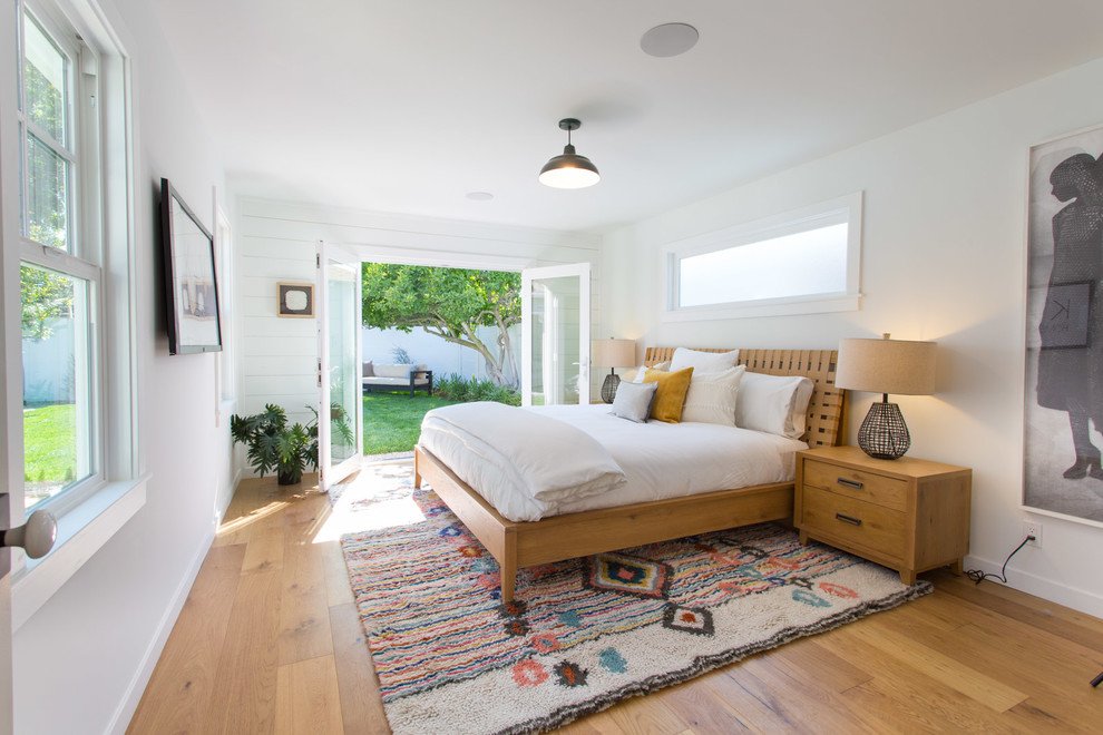 ロサンゼルスにある中くらいなビーチスタイルのおしゃれな主寝室 (白い壁、無垢フローリング、ベージュの床)