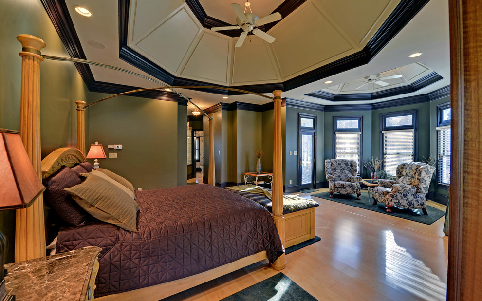 Immagine di una camera da letto tradizionale con pareti verdi e parquet chiaro
