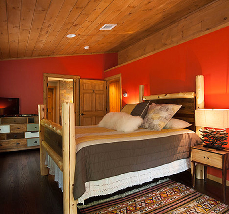 На фото: гостевая спальня (комната для гостей), среднего размера в стиле рустика с темным паркетным полом, коричневым полом и красными стенами без камина с