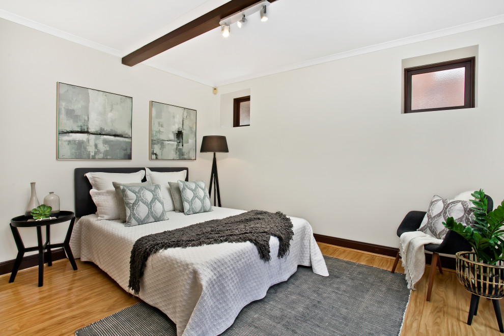シドニーにある中くらいなトランジショナルスタイルのおしゃれな主寝室 (無垢フローリング、白い壁、茶色い床) のインテリア