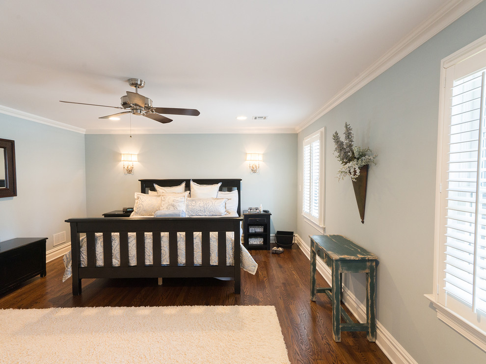 Cette photo montre une chambre parentale chic avec un mur bleu et un sol en bois brun.