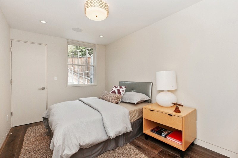 Ejemplo de dormitorio principal contemporáneo de tamaño medio sin chimenea con paredes blancas, suelo de baldosas de porcelana y suelo marrón