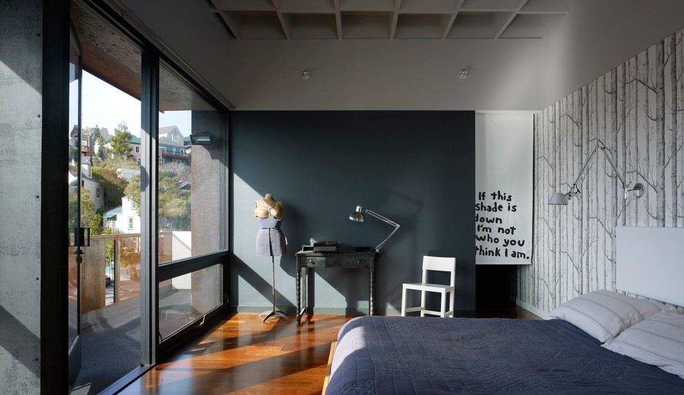 Imagen de dormitorio principal contemporáneo de tamaño medio con suelo de madera en tonos medios y paredes grises