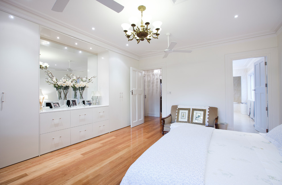 На фото: спальня в современном стиле с белыми стенами и светлым паркетным полом без камина с