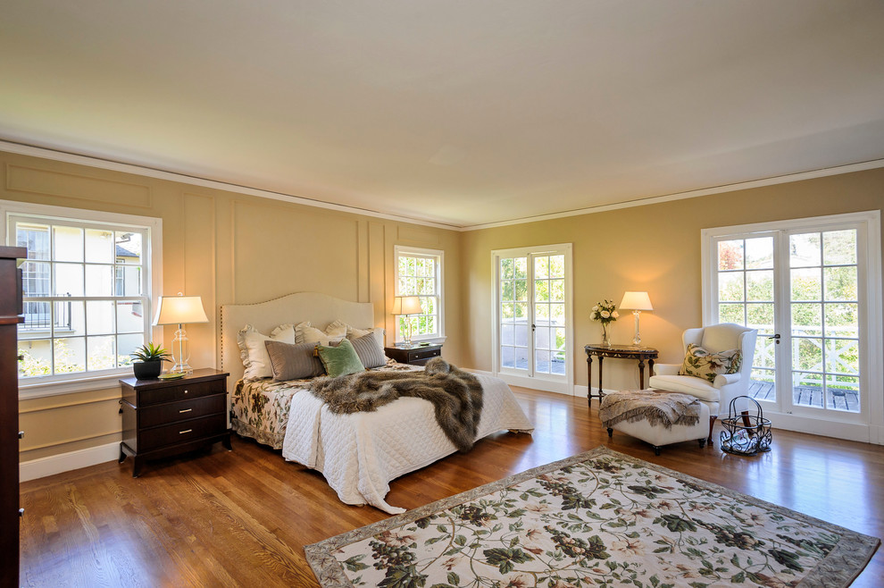Idées déco pour une chambre classique avec un mur beige et un sol en bois brun.