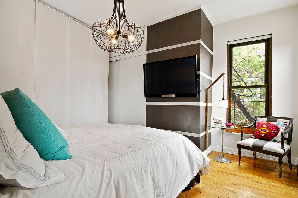 Foto de dormitorio principal actual pequeño sin chimenea con paredes blancas, suelo de madera en tonos medios y suelo beige