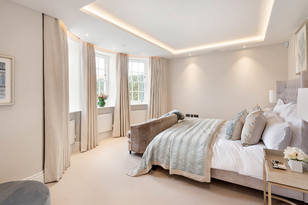 Design ideas for a traditional bedroom in London with beige walls, carpet and beige floors.