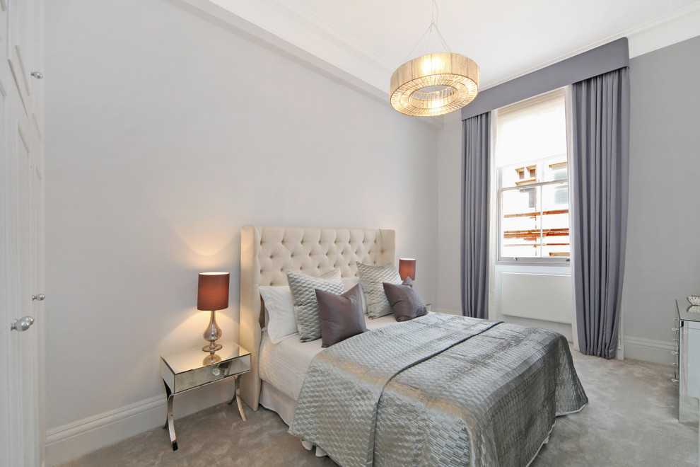 This is an example of a large traditional grey and silver bedroom in London with grey walls, carpet and grey floors.