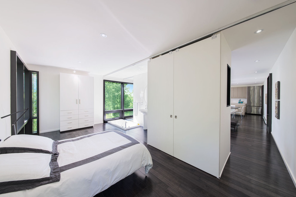 На фото: спальня в стиле модернизм с белыми стенами, темным паркетным полом и черным полом без камина с