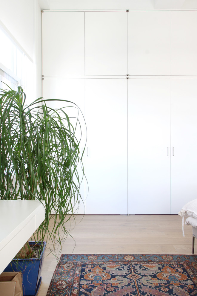 Foto di una camera matrimoniale minimal di medie dimensioni con pareti bianche e parquet chiaro