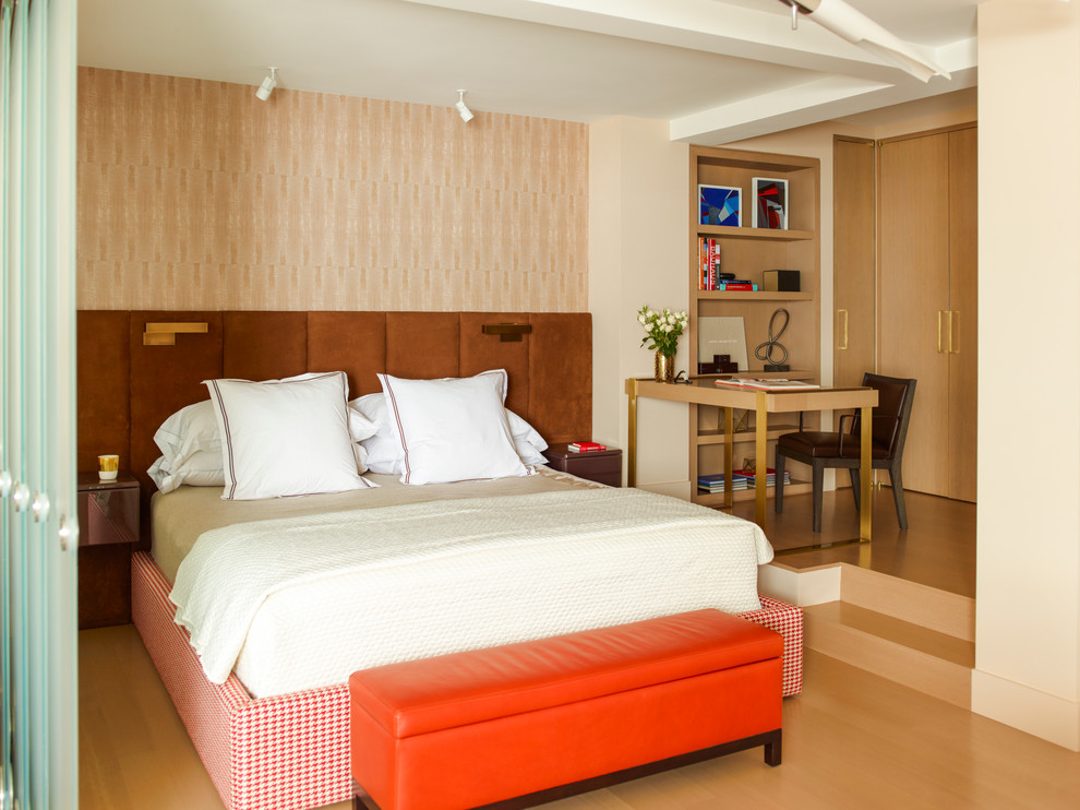 Aménagement d'une chambre mansardée ou avec mezzanine contemporaine avec un mur beige et parquet clair.