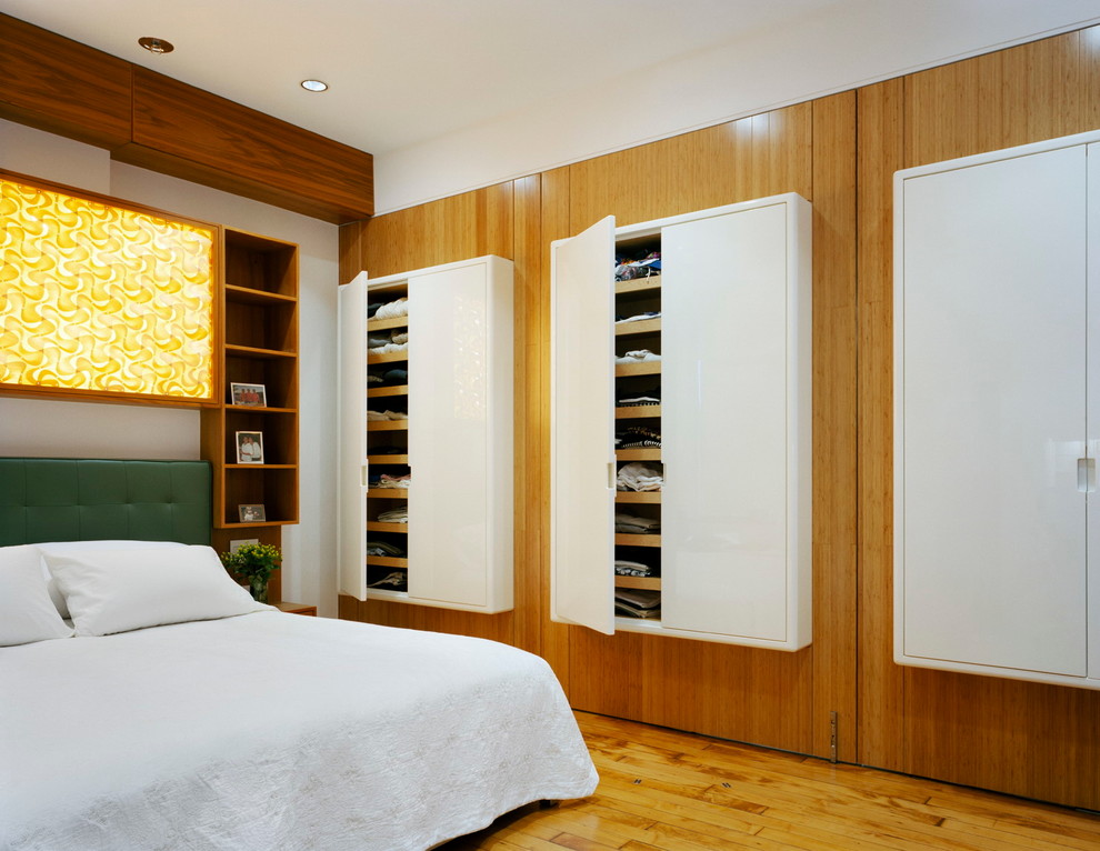 На фото: спальня в современном стиле с паркетным полом среднего тона с