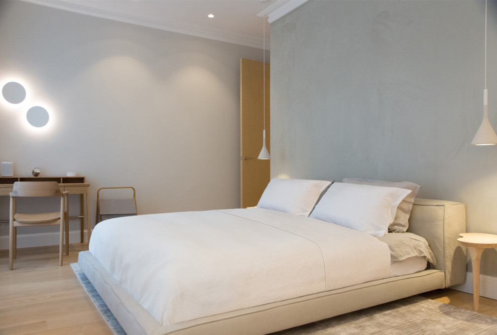 Inspiration pour une chambre parentale minimaliste de taille moyenne avec un mur gris.