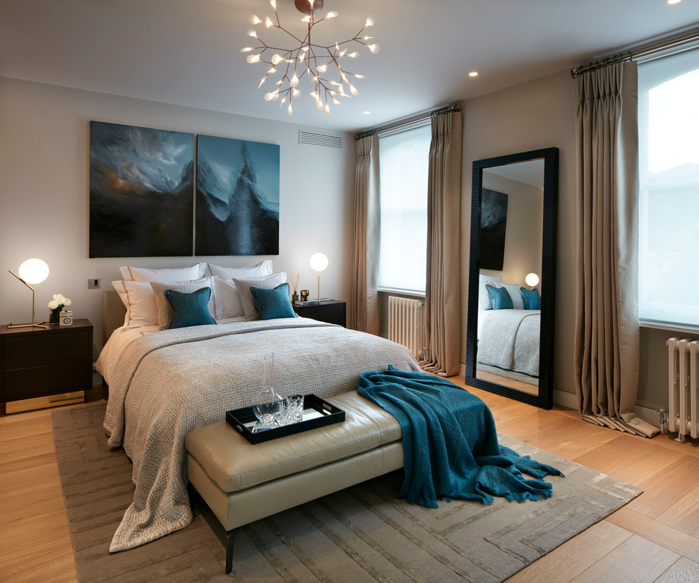 Medium sized traditional grey and brown bedroom in London with brown walls, light hardwood flooring and beige floors.