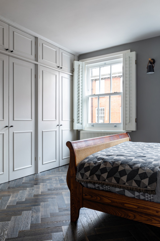 На фото: хозяйская спальня среднего размера в стиле неоклассика (современная классика) с серыми стенами, темным паркетным полом и серым полом