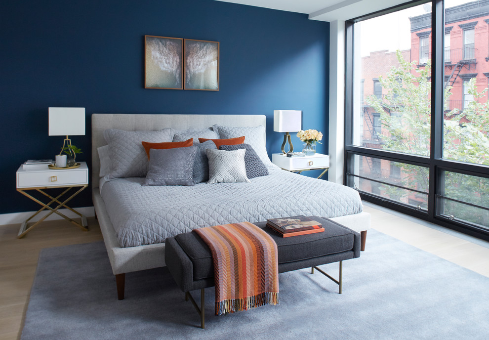 This is an example of a medium sized contemporary guest bedroom in Other with blue walls, light hardwood flooring, beige floors and no fireplace.