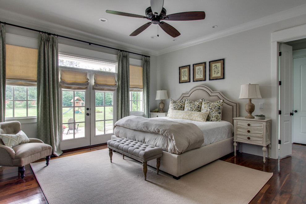 Imagen de dormitorio principal clásico de tamaño medio sin chimenea con paredes grises y suelo de madera en tonos medios