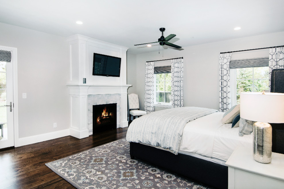 Design ideas for a large classic master bedroom in Denver with grey walls, dark hardwood flooring, a standard fireplace, a tiled fireplace surround and brown floors.