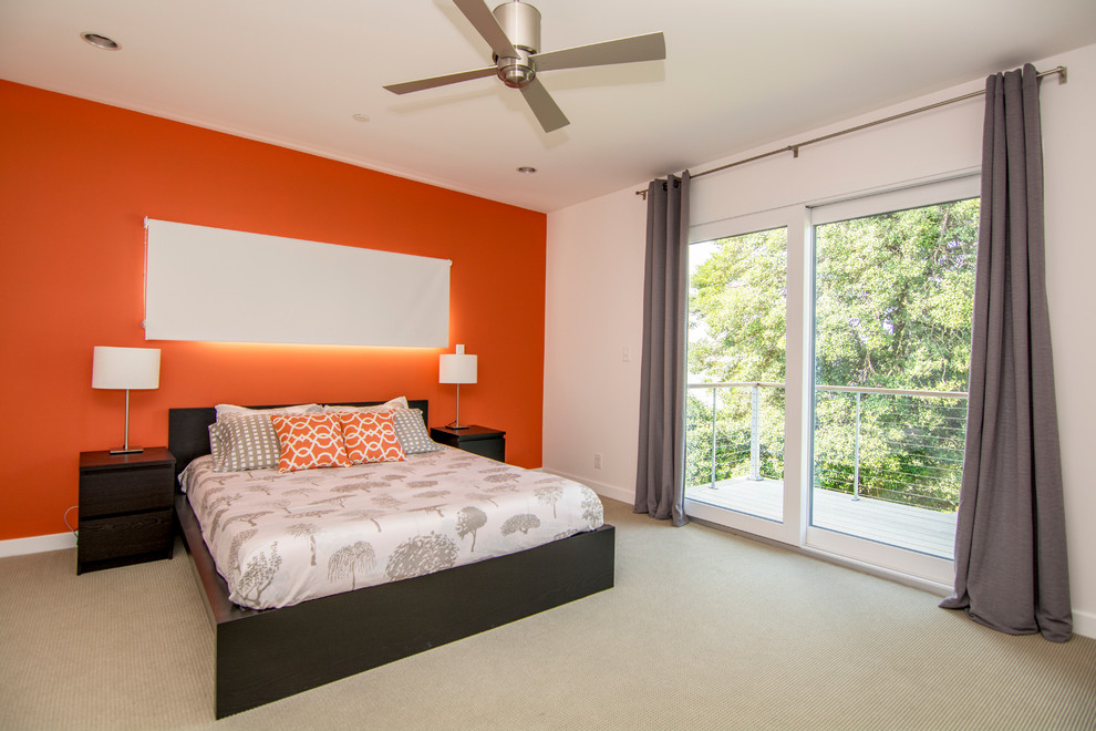 Immagine di una camera matrimoniale minimalista con pareti arancioni e moquette