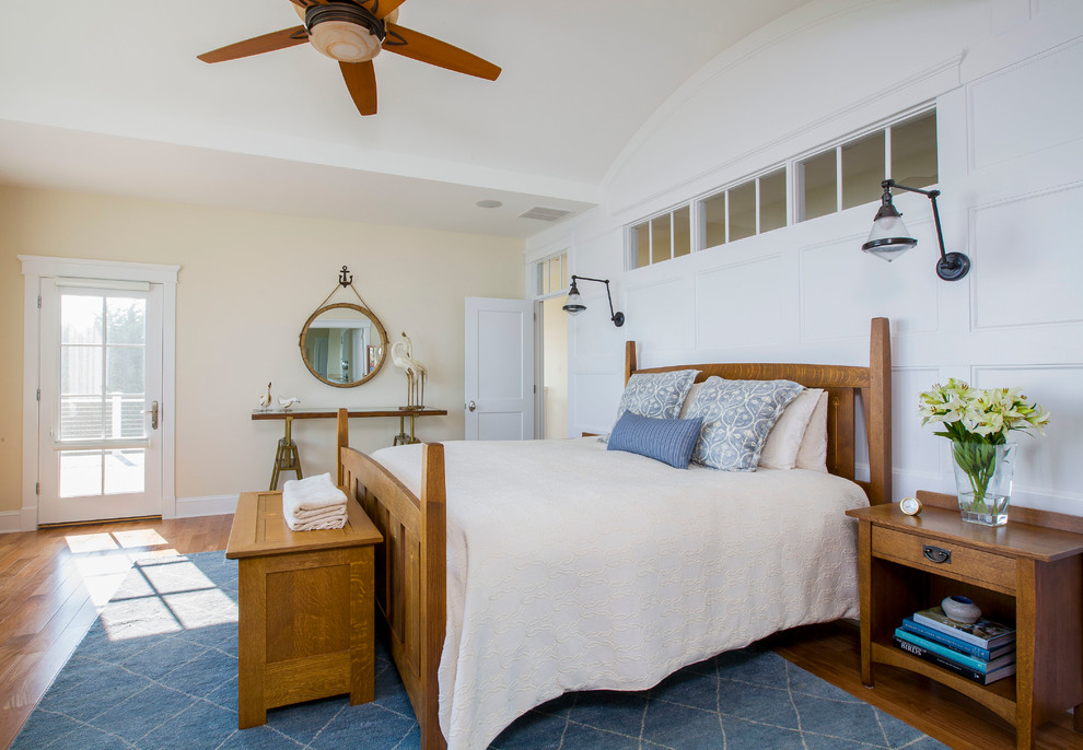 Modelo de dormitorio principal costero con paredes beige y suelo de madera clara
