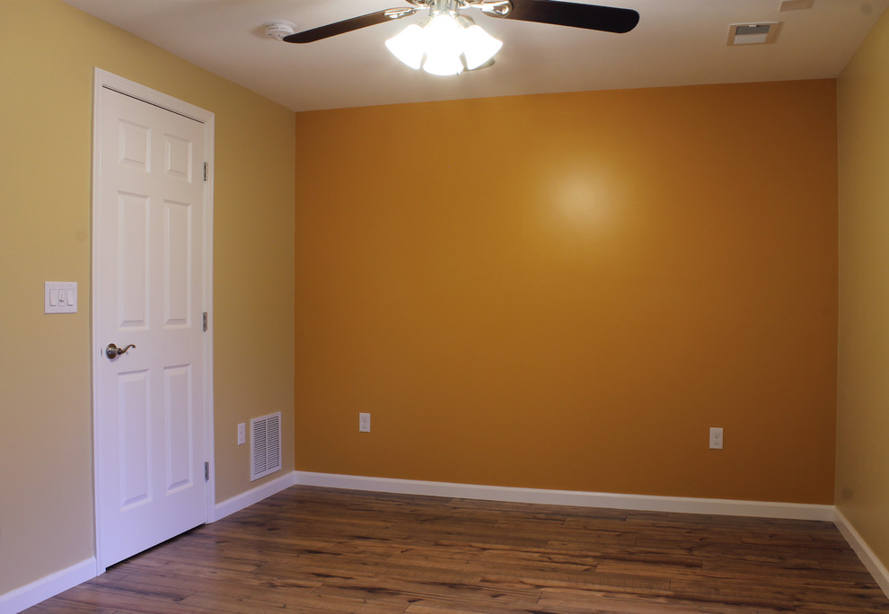 Ejemplo de dormitorio principal actual de tamaño medio con paredes beige y suelo laminado
